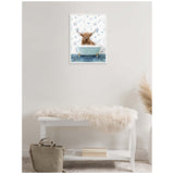Framed canvas of a brown Highland cow sitting in a blue clawfoot bathtub with light blue underwater-themed wallpaper behind, hung above a white bench with a fur throw.