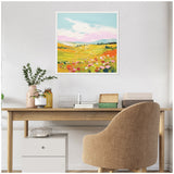 Framed colorful meadow landscape painting with green, yellow, pink, and orange hues hanging above a wooden desk with beige chair and decorative items.