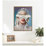 Framed canvas art depicts a woman with white hair and red lips, a large white moth covering her eyes, and a moon phase halo against a starry gradient background.