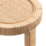 Close-up of a round woven rattan table top with tightly wrapped rattan edges and a matching rattan-wrapped leg in light natural tones.