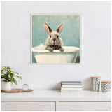 Framed artwork showing a fluffy gray bunny with upright ears sitting in a white bubble-filled bathtub against a muted blue background.