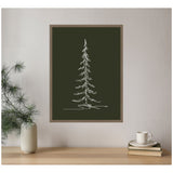 Minimalist white line sketch of a tall evergreen tree on dark green background, framed and hanging on a light wall above a wooden surface with a vase and stacked books