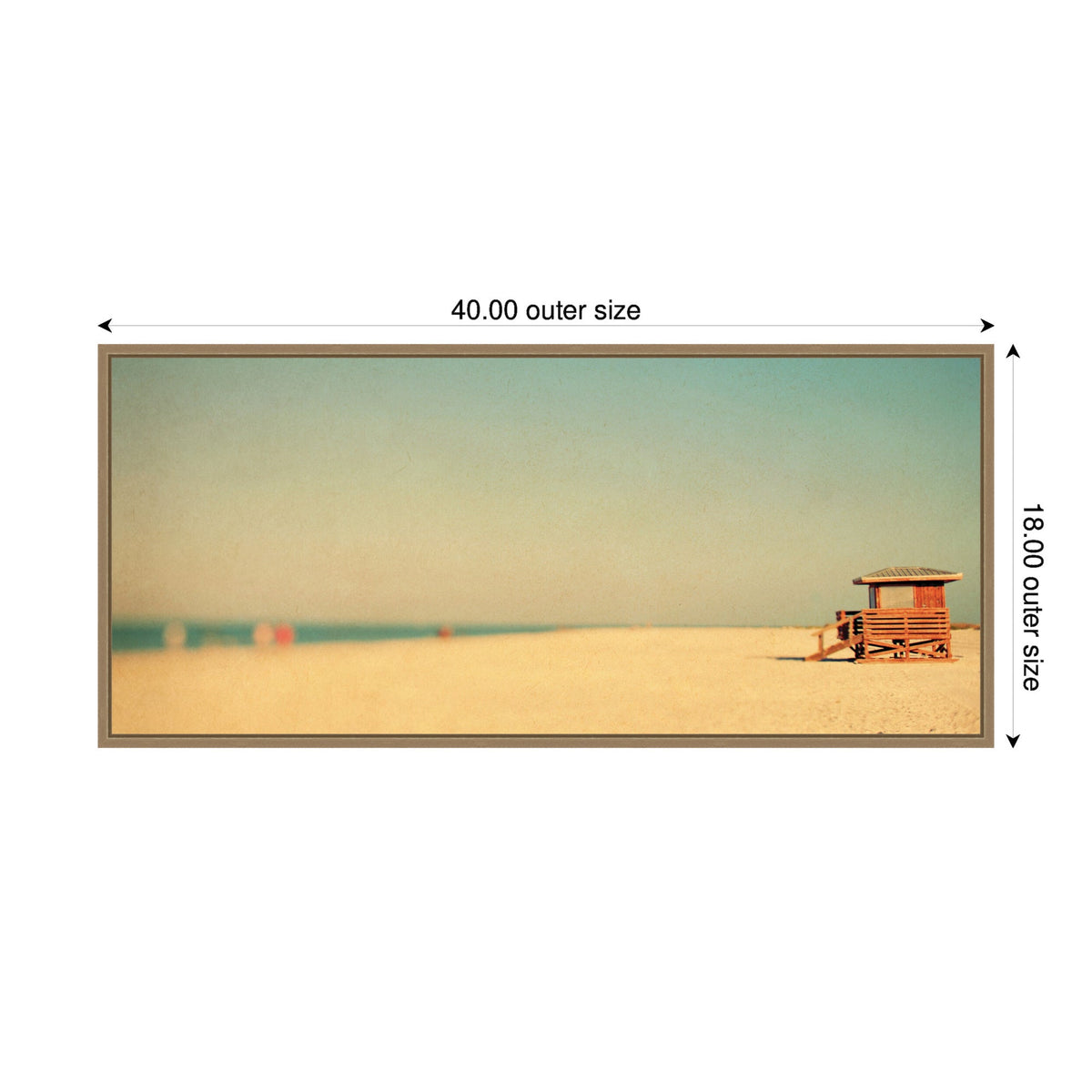 Framed canvas print showing a sandy beach with a wooden lifeguard hut on the right and a clear blue sky above, with distant blurred beachgoers on the horizon.