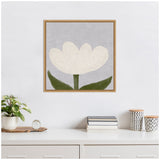 Framed canvas art print of a white tulip with green leaves on a muted gray background, displayed above a white desk with books, plants, and patterned containers.