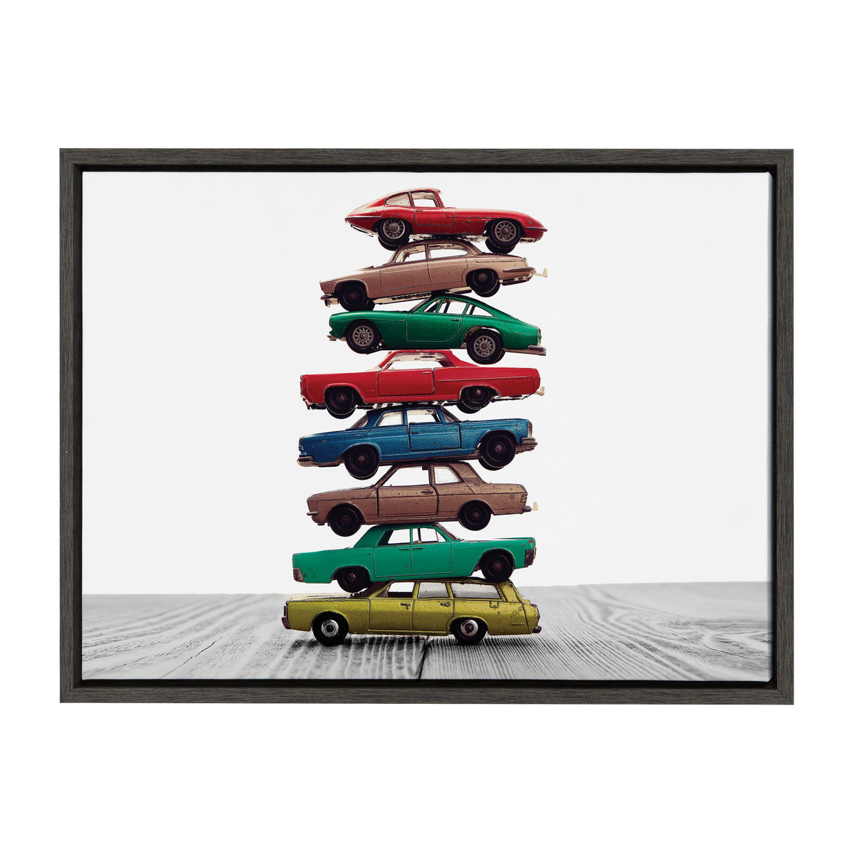 Eight vintage toy cars stacked vertically in varied colors including red, yellow, green, blue, and brown, set against a white background on wood grain surface.