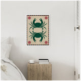 Framed canvas art featuring two symmetrical dark green crabs on a beige background with red sun motifs and a red and green striped border, hung on a white wall above a wooden bedside table.