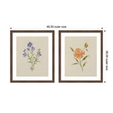 Two framed floral prints side by side, one with delicate purple flowers and green stems, the other with soft orange flowers and green leaves, both on beige textured backgrounds.