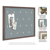 Rectangular pinboard with a muted blue canvas featuring a repeating light beige botanical print, framed in a medium brown wood, holding two vintage-style black-and-white photos.