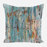 Square pillow with abstract brushstroke pattern in teal, rusty orange, beige, and gray, creating a textured, layered painterly effect.