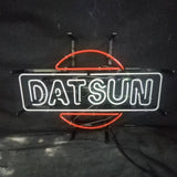 Neon sign displaying the word 'DATSUN' in white letters framed by a rectangular outline with a stylized red circle partially intersecting it against a dark background.