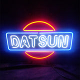 DATSUN Car Neon Sign mounted on a wall, glowing in bright orange hue on metal grid backing