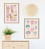 Wall display with two framed artworks featuring pink-themed matchboxes and multicolored seashells with bows, a round woven basket above, and a wooden cabinet with a potted fern below.