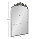 Traditional arch-shaped mirror with an ornate dark metallic frame and detailed scrolling leaf motif at the top, measuring 30.75 by 19 inches.