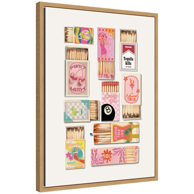 Framed canvas wall art print showing a collection of vintage pink matchboxes with retro-style colorful designs inside a natural wood grain Sylvie float frame.