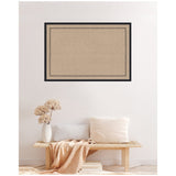 Rectangular tan pinboard with a delicate black scallop print border, framed in black, hanging on a white wall above a wooden bench with neutral pillows and a textured beige throw.