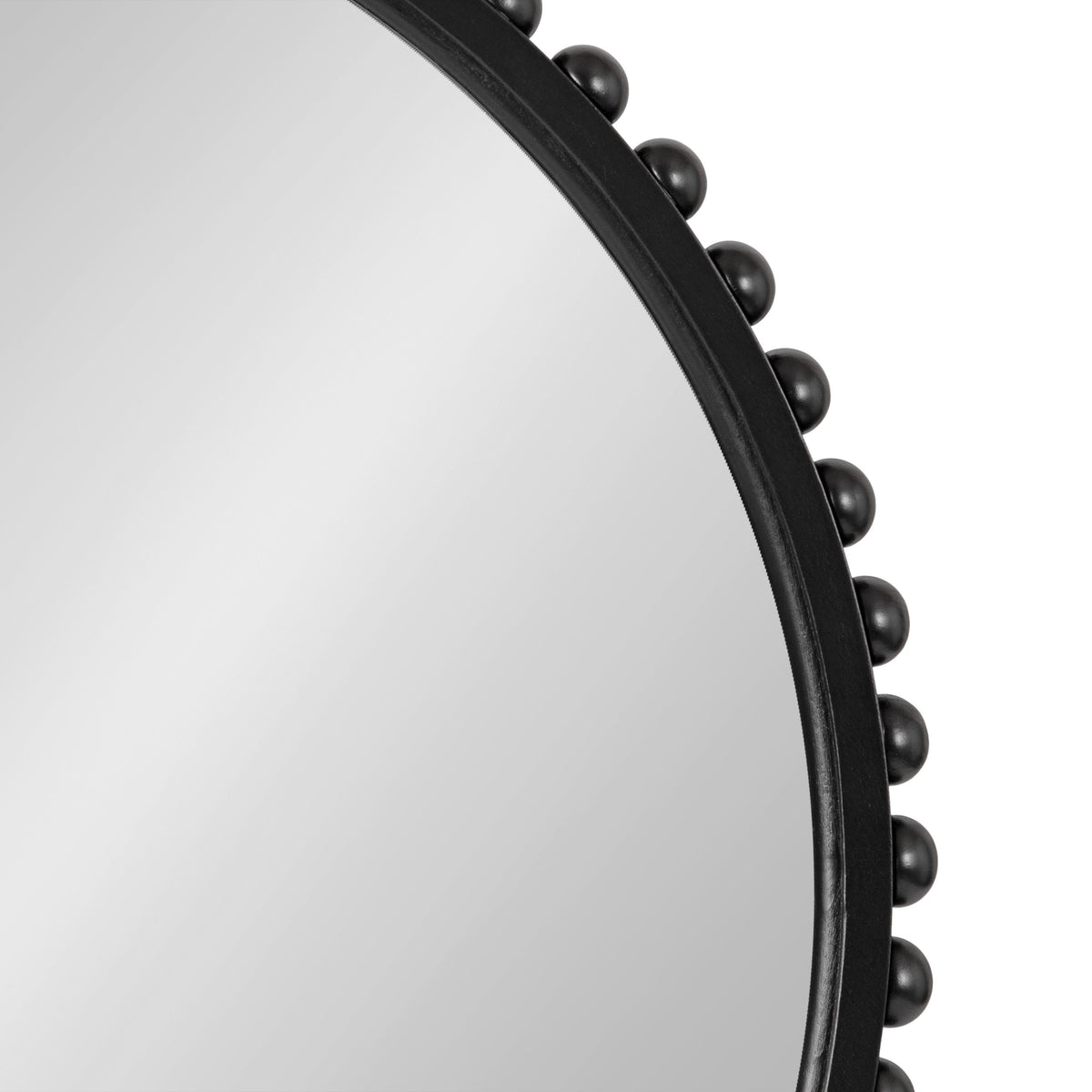 Close-up of a round mirror with a smooth black frame decorated with evenly spaced black spherical beads along the edge, against a white background.