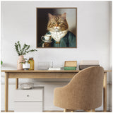 Framed canvas portrait of a brown tabby cat wearing a teal velvet jacket and white ruffled collar, holding a teacup against a muted dark background, hanging above a wooden desk