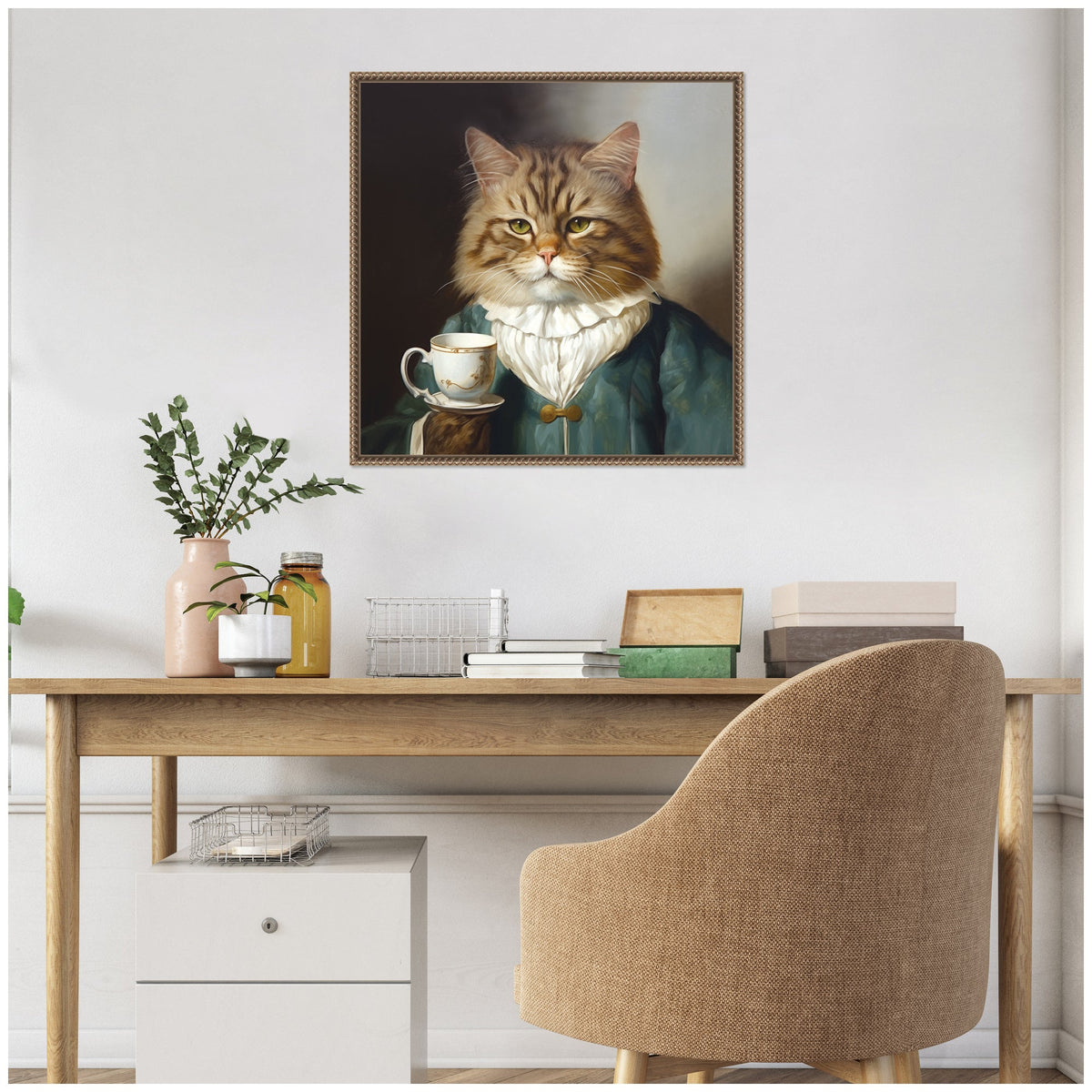 Framed canvas portrait of a brown tabby cat wearing a teal velvet jacket and white ruffled collar, holding a teacup against a muted dark background, hanging above a wooden desk