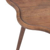 Close-up of a scalloped edge wooden coffee table top with smooth, rounded curves and a warm brown finish, showing one tapered leg beneath.