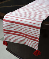 Woven cotton table runner in off white and red laid on a dining table