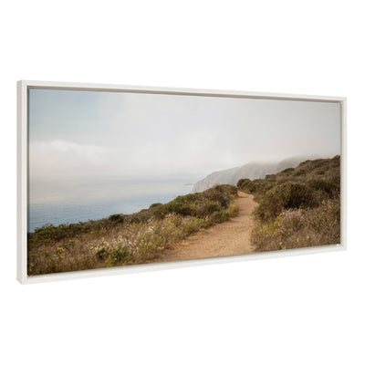Framed canvas art depicting a coastal scene with waves crashing on rocky shores