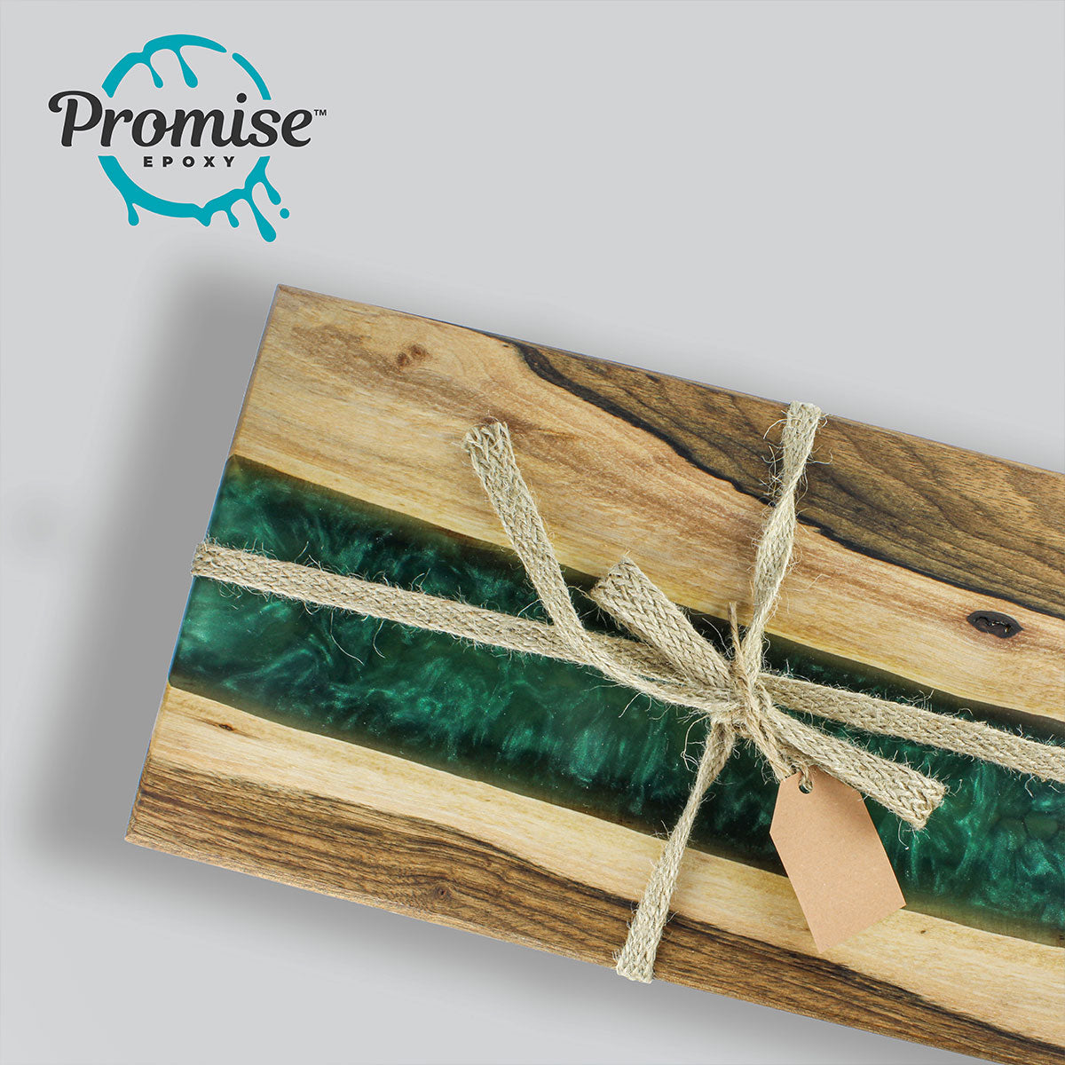 Rectangular wooden board with a glossy, deep green resin river running through the center, tied with natural fiber string and a blank brown tag on light gray background.