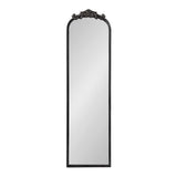 Tall rectangular mirror with rounded top and ornate black decorative crest featuring floral and scroll motifs at the arch.
