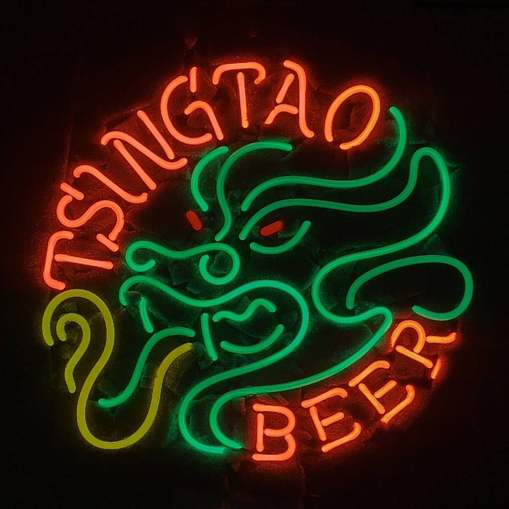 Neon sign with orange text 'TSINGTAO BEER' encircling a green stylized dragon breathing yellow flames on a black background.