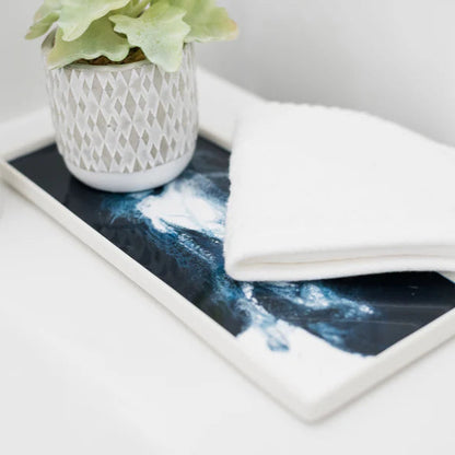 Tablet with a space-themed resin ceramic tray on a white surface with a plant and towel.