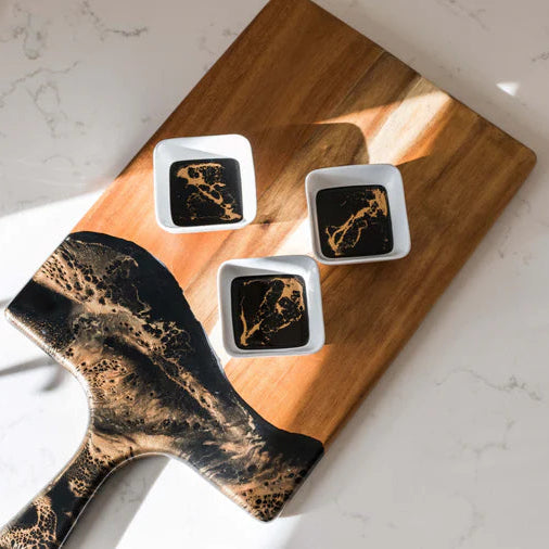Wooden resin charcuterie board with abstract design on a marble surface