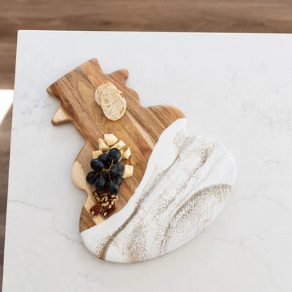 Snowman Acacia Resin Board with marble base holding bread, grapes, and nuts on a marble surface.