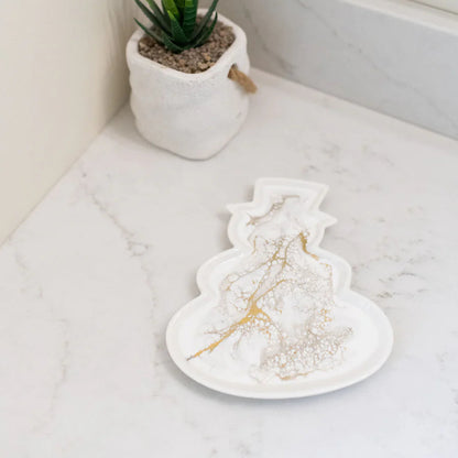 Resin Ceramic Snowman Tray on a marble surface with a potted plant in the background.