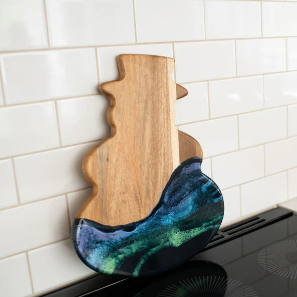 Snowman Acacia Resin Board with a colorful resin design on a kitchen counter.