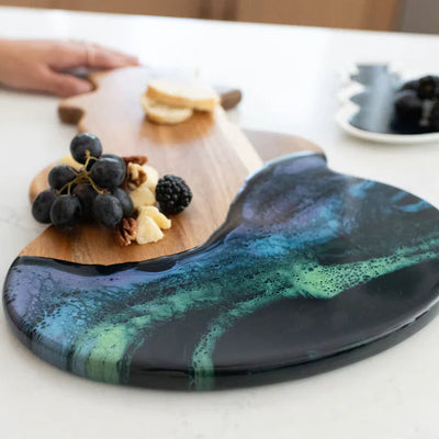 Snowman Resin Charcuterie Board with colorful resin design on acacia wood, displayed on kitchen counter