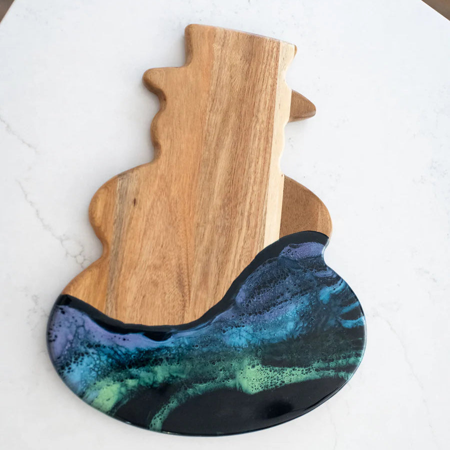 Snowman Resin Charcuterie Board with colorful resin design on acacia wood, displayed on kitchen counter