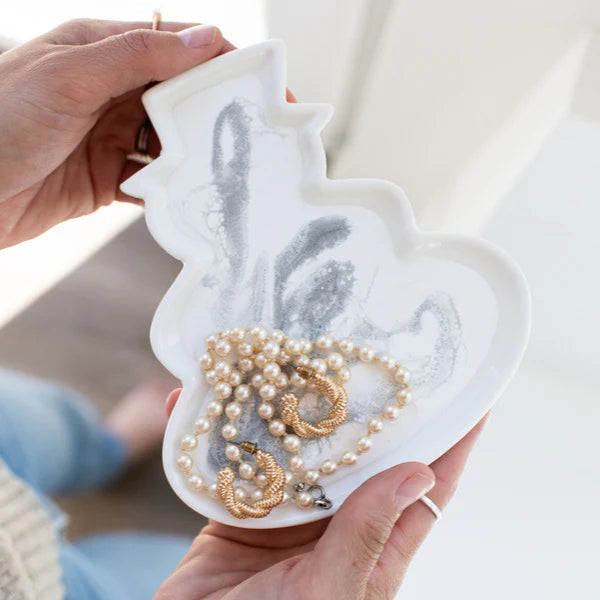Resin Ceramic Snowman Tray jewelry organizer with necklaces held by a person against a neutral background