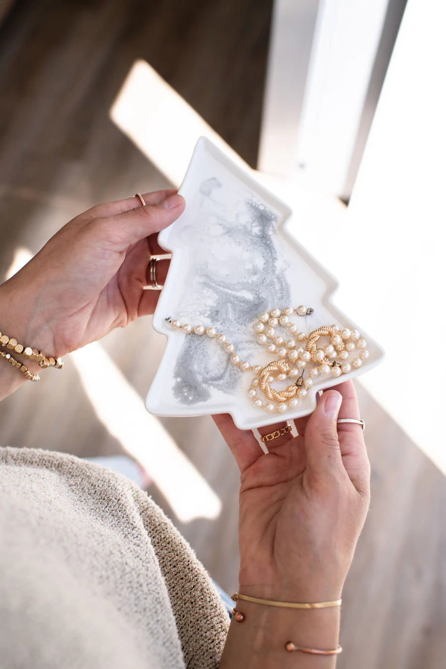 Person holding a tree Resin Ceramic Tray with necklaces and bracelets.