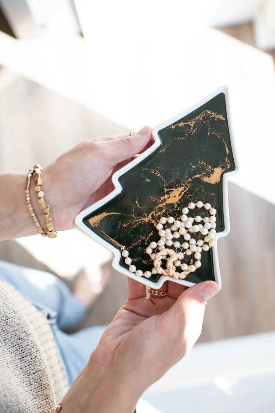 Tree Resin Ceramic Tray a black and gold marbled phone case with a pearl necklace inside.