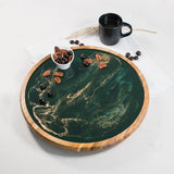 Round acacia wood lazy susan with hand-poured resin design, shown with snacks and drinks on a table