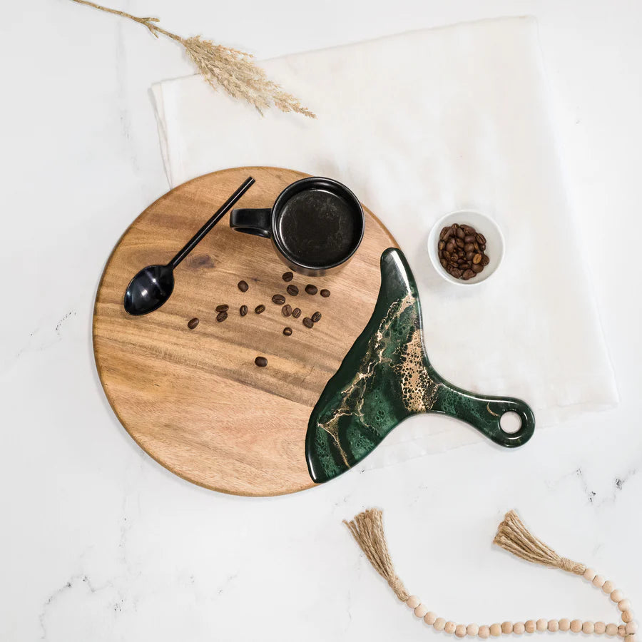 Wooden Cheese Paddle Acacia Serving Charcuterie Board with a marble handle knife, black mug, and coffee beans on a white surface.