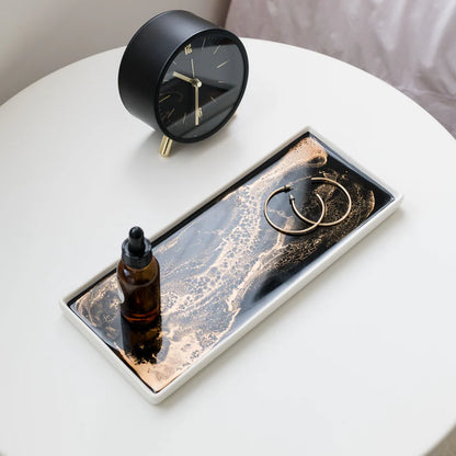 resin ceramic tray with a bottle, rings, and clock on a white surface