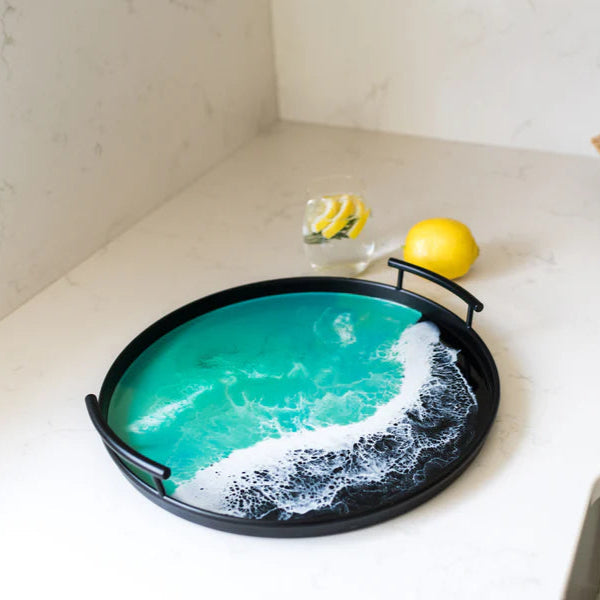 Decorative resin tray with ocean wave design on a white surface