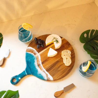 Round acacia wood charcuterie board with colorful resin handle by Lynn & Liana Designs