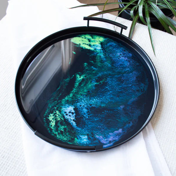 Round resin tray with a colorful abstract design on a white surface