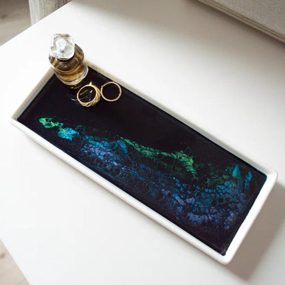 Decorative Small Ceramic Resin Tray  with rings and perfume bottle on a white surface