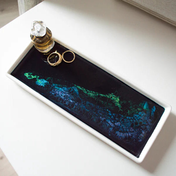 Decorative Small Ceramic Resin Tray  with rings and perfume bottle on a white surface