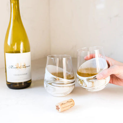 Wine bottle with a resin wine glass of white wine on a table