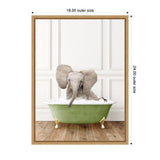 Young elephant sitting in green clawfoot bathtub filled with bubbles on wooden floor against white paneled wall, framed with light wood border.
