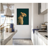 Profile of a golden cheetah with black spots on a dark green background, hanging on a white wall in a bright, modern kitchen with grey countertops and ceramic mugs.