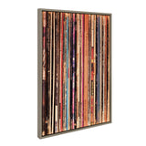 Vertical close-up of a framed canvas print showing a tightly packed row of colorful vinyl record spines with varied text and patterns.